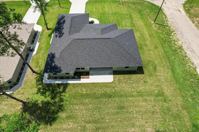 an aerial view of residential house with outdoor space and trees all around