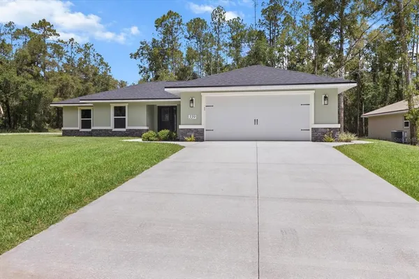 a front view of a house with a yard and garage
