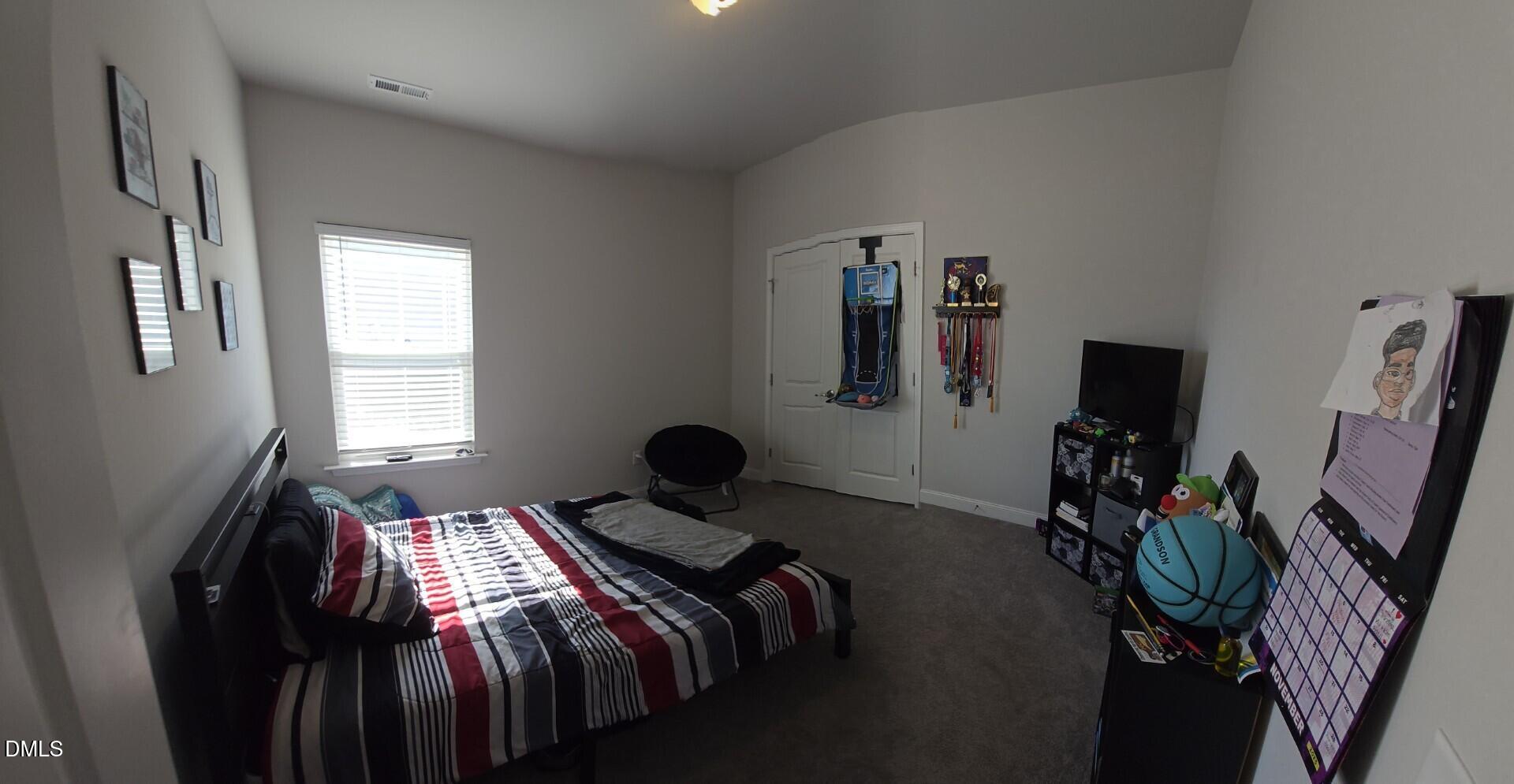 207 Spring Forest Drive Goldsboro, NC 27534 - Photo 4 of 19 a bedroom with a bed and a flat tv screen on a dresser