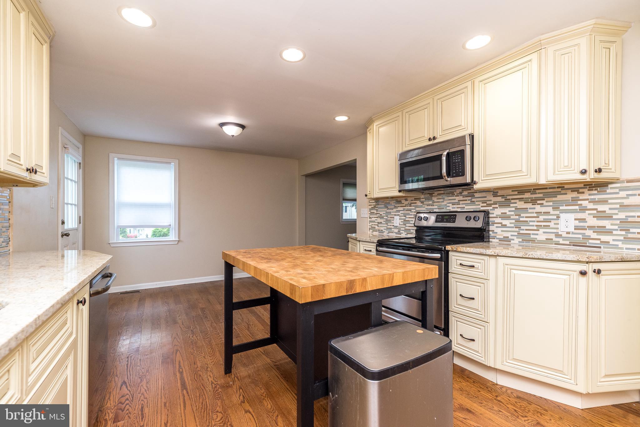 1425 Leedom Road Havertown, PA 19083 - Photo 10 of 46 a kitchen with stainless steel appliances granite countertop a stove top oven a sink dishwasher and a microwave with wooden floor