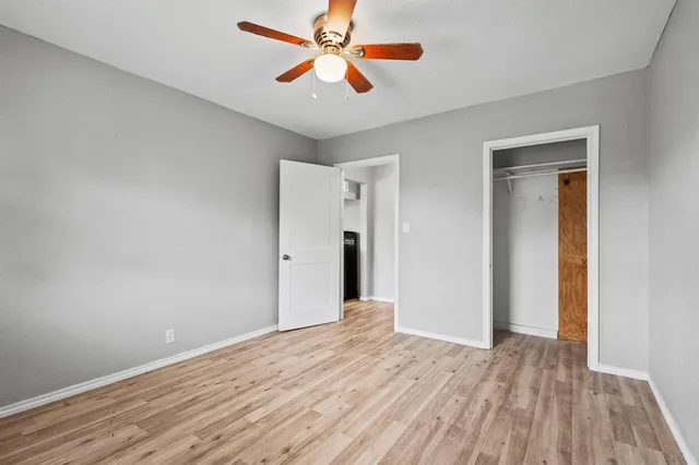 a view of a room with wooden floor and a ceiling fan