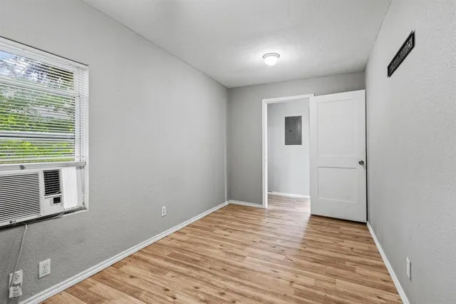 a view of a room with wooden floor and a window