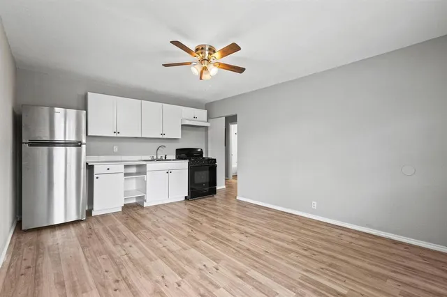 a kitchen with a refrigerator and white cabinets