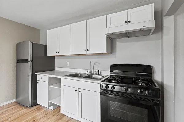a kitchen with cabinets appliances and a sink