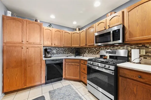 a kitchen with stainless steel appliances granite countertop a stove a sink and a microwave