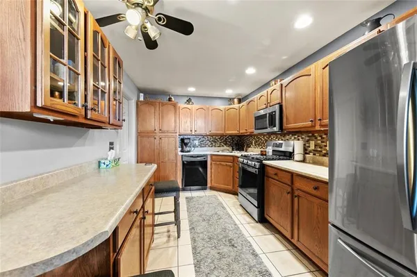 a kitchen with stainless steel appliances granite countertop a refrigerator a stove and a sink with cabinets