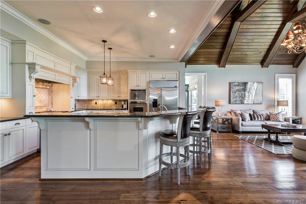204 Eagle Bend Drive Waxhaw, NC 28173 - Photo 6 of 24 a kitchen with stainless steel appliances granite countertop a stove top oven a sink a dining table and chairs with wooden floor