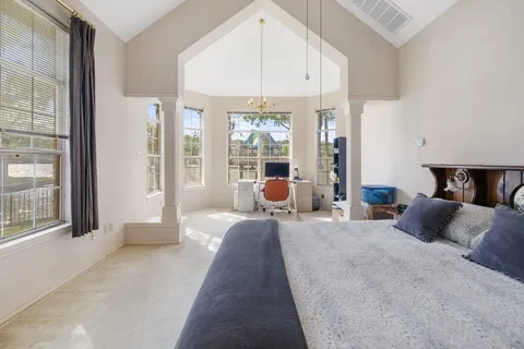 a bedroom with a bed and large windows