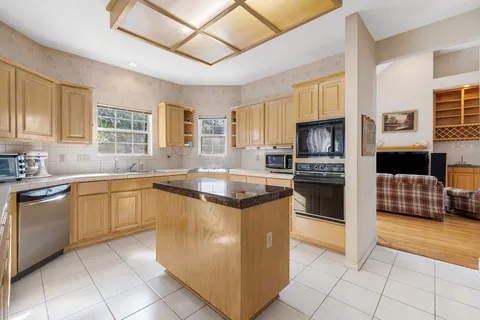 a kitchen with stainless steel appliances granite countertop a stove top oven a sink a counter top space and cabinets