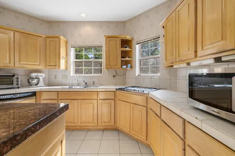 a kitchen with stainless steel appliances granite countertop a sink stove and cabinets