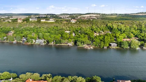 an aerial view of residential houses with outdoor space and lake view