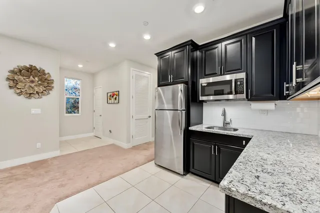 a kitchen with granite countertop a refrigerator and a sink