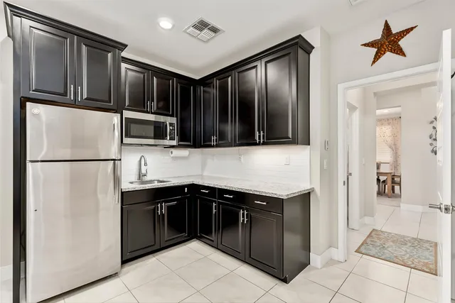 a kitchen with stainless steel appliances granite countertop a refrigerator and a sink