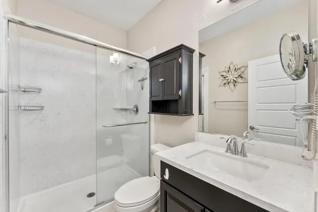 a bathroom with a granite countertop sink toilet and shower