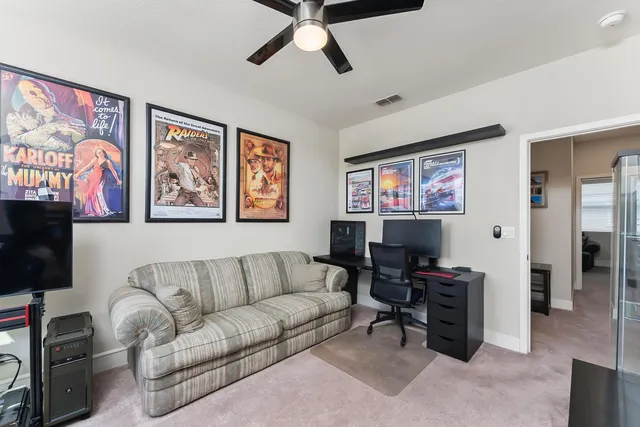 a living room with furniture a ceiling fan and a window