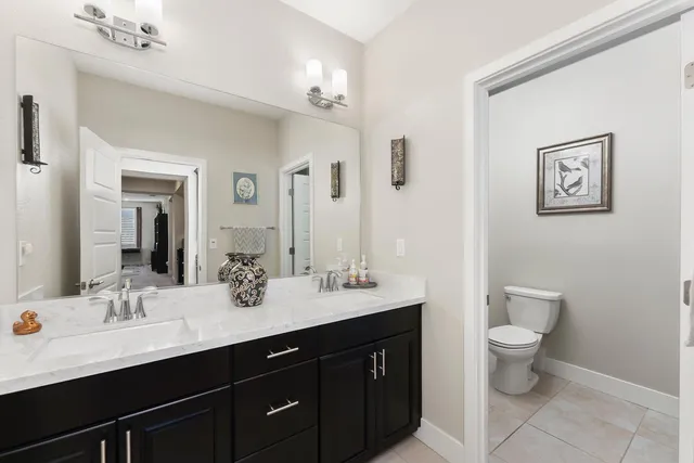 a bathroom with a double vanity sink toilet and a mirror