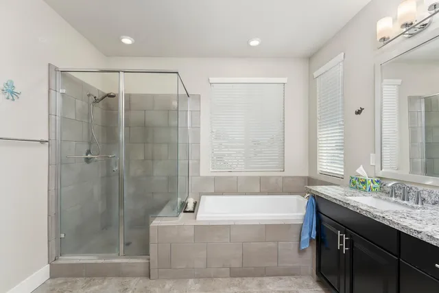 a bathroom with a granite countertop bathtub shower sink and toilet