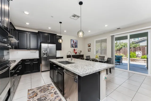 a kitchen with stainless steel appliances granite countertop a sink stove and refrigerator