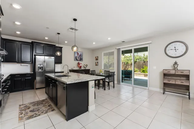 a kitchen with stainless steel appliances kitchen island granite countertop a stove a sink and a refrigerator