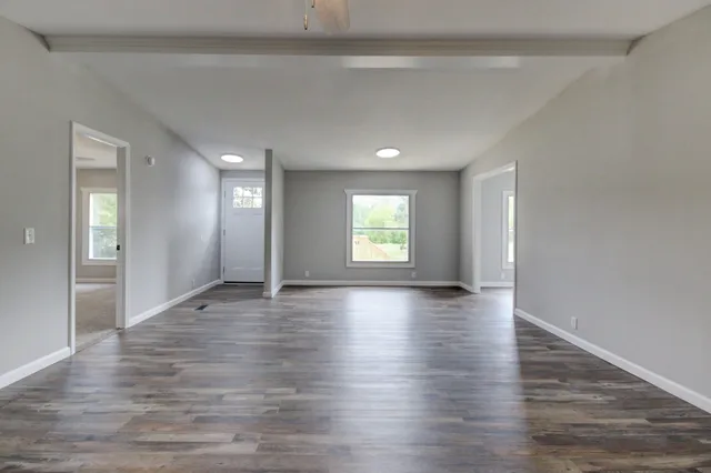 an empty room with a window and a fan