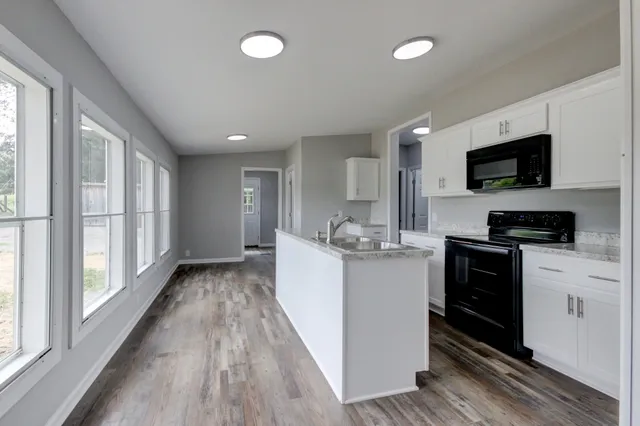 a kitchen with a stove and a white wooden cabinets
