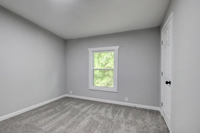 a front view of a house with a yard and trees