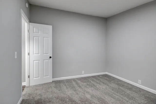 a backyard of a house with lawn chairs and wooden fence