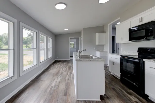 a kitchen with stainless steel appliances granite countertop a sink stove and cabinets