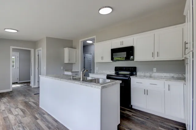 a kitchen with stainless steel appliances granite countertop a sink a stove and a microwave