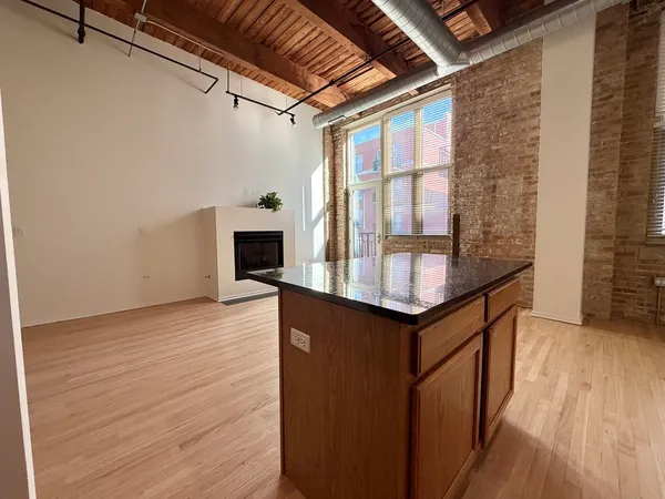 a kitchen with granite countertop a stove cabinets and wooden floor