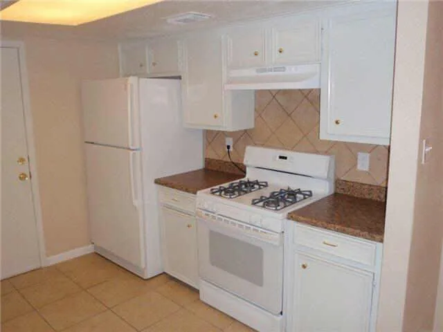 a kitchen with white cabinets and white appliances