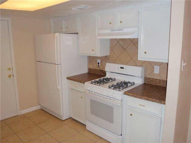 a kitchen with white cabinets and white appliances