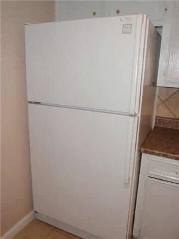a white refrigerator freezer and a stove sitting inside of a kitchen