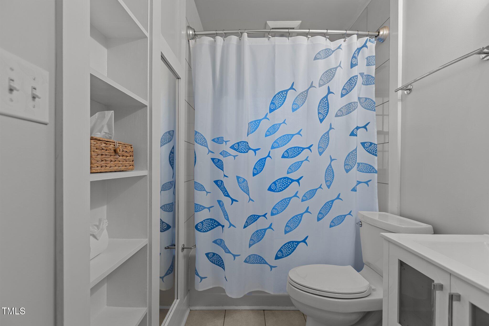 1811 Ridley Street Raleigh, NC 27608 - Photo 24 of 48 a white toilet sitting next to a shower curtain