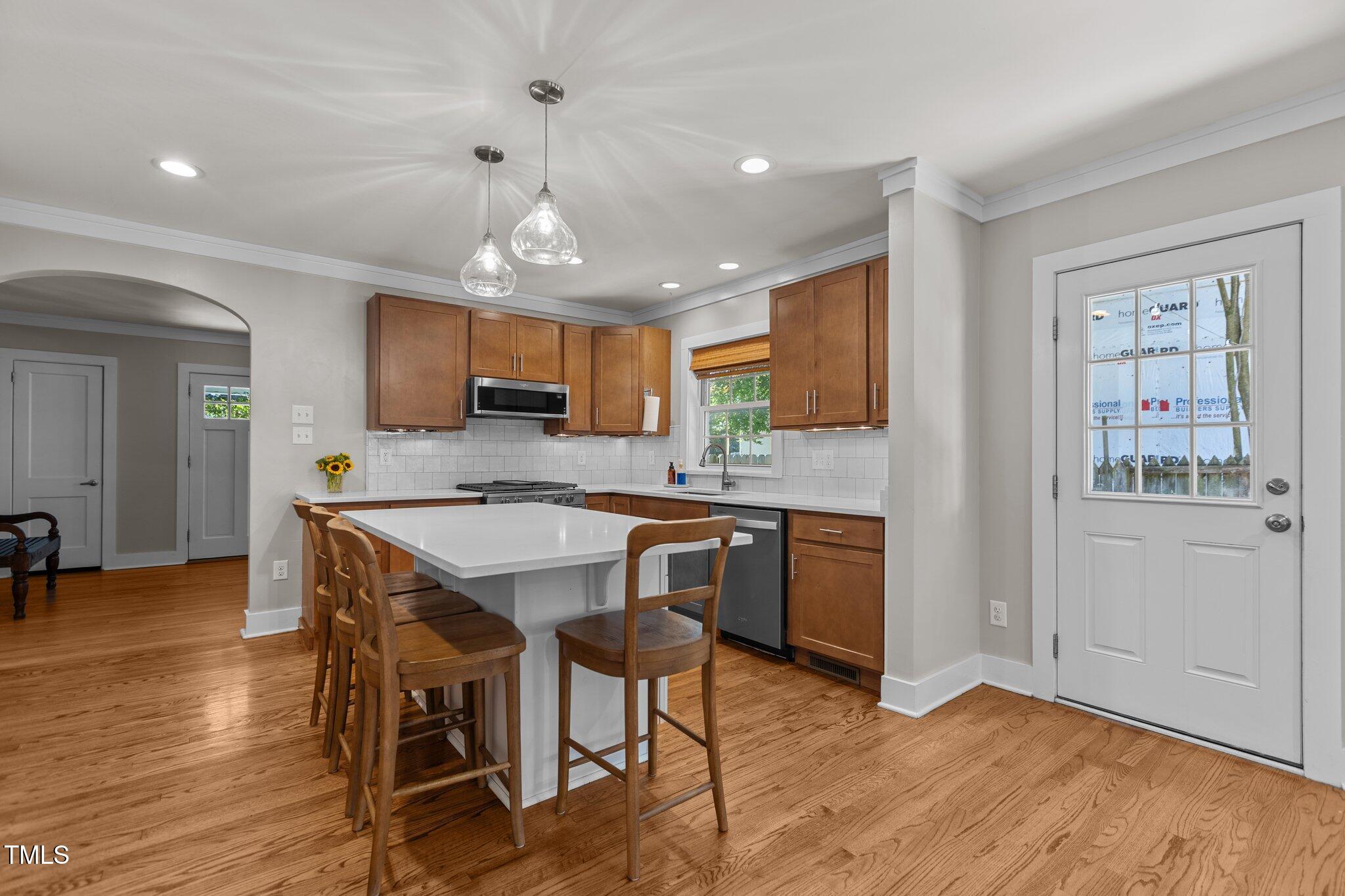 1811 Ridley Street Raleigh, NC 27608 - Photo 6 of 48 a kitchen with stainless steel appliances granite countertop wooden cabinets a refrigerator a sink a stove a dining table and chairs