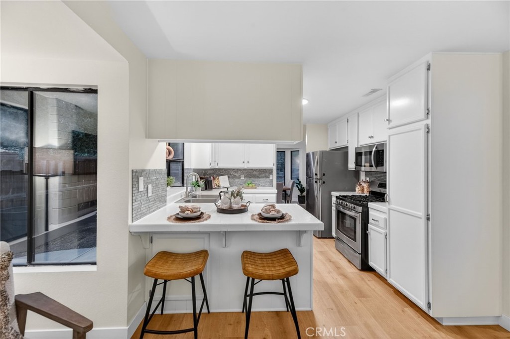 32042 Merlot Court Temecula, CA 92591 - Photo 13 of 46 a kitchen with stainless steel appliances kitchen island granite countertop a refrigerator and a stove top oven