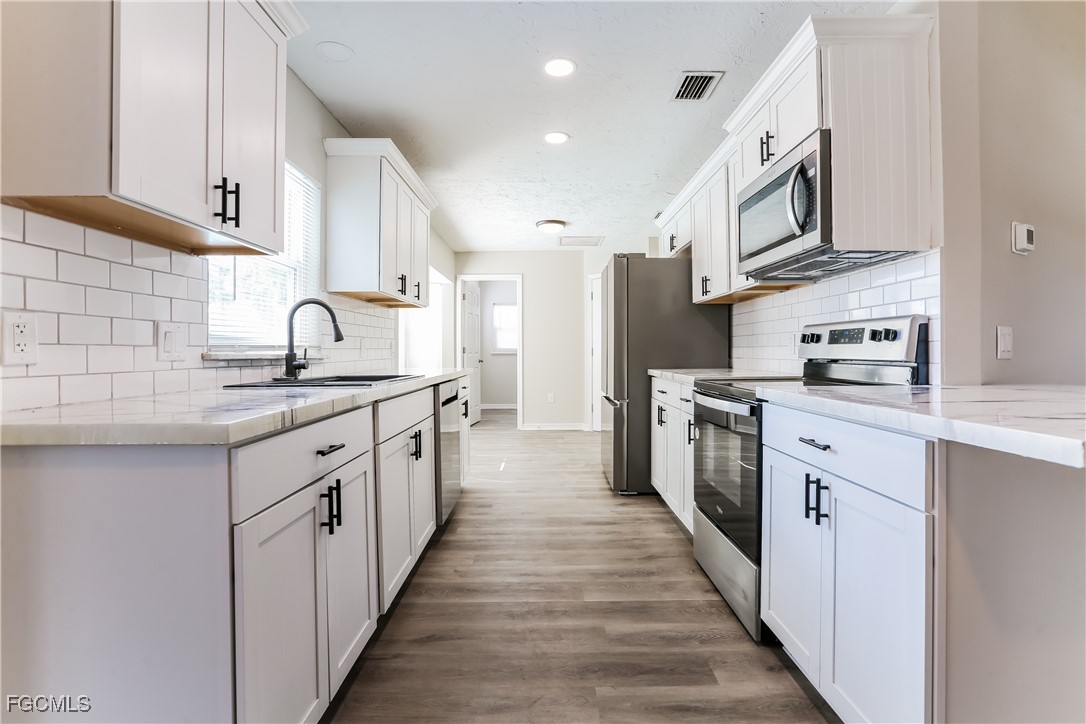 4007 Allure Lane North Port, FL 34287 - Photo 4 of 16 a kitchen with stainless steel appliances granite countertop lots of white cabinets a sink and dishwasher