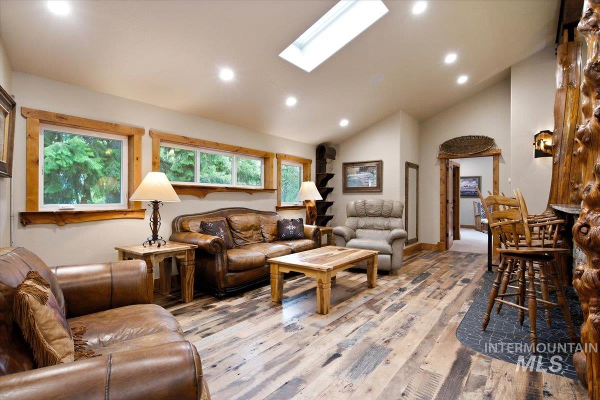 1029 Cee Way Loop McCall, ID 83638 - Photo 25 of 50 Wood-finish flooring throughout, featuring a built-in bar with stone-clad base, integrated cabinetry, and pendant lighting