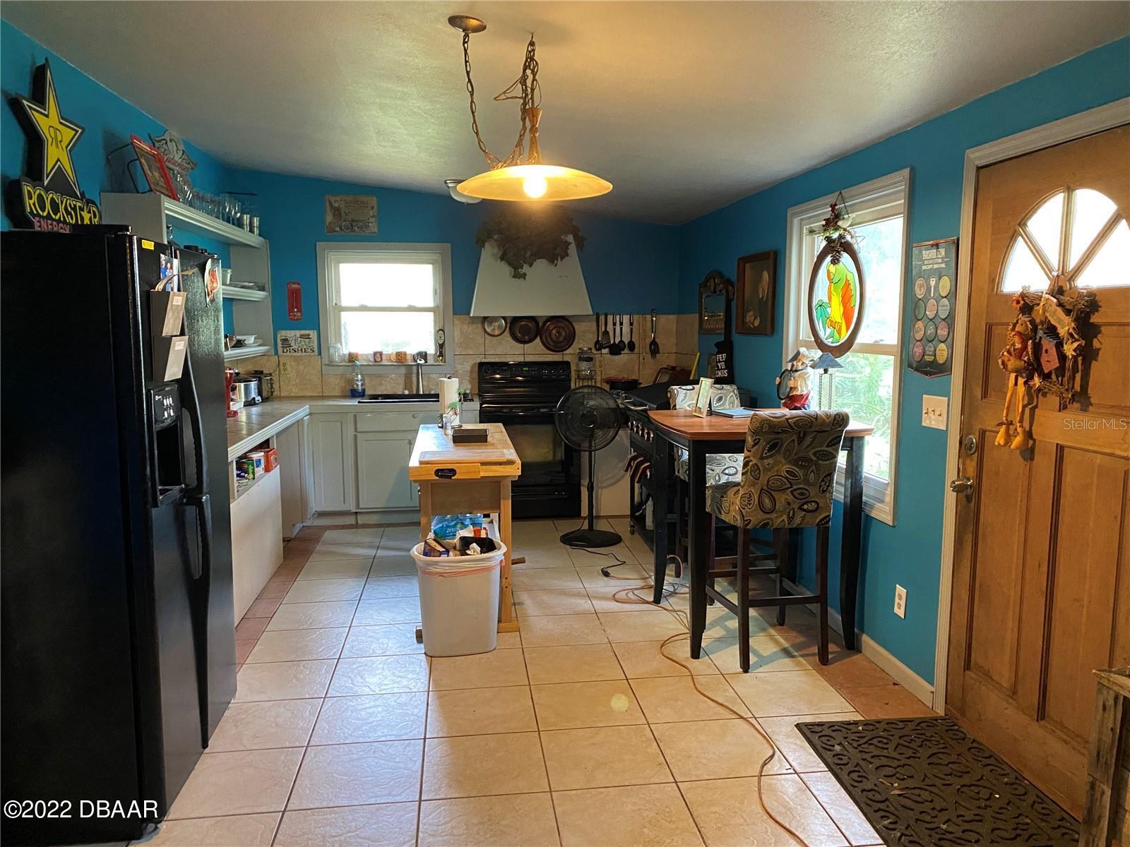4580 Ave D St. Augustine, FL 32095 - Photo 5 of 10 a living room with dining table and a refrigerator