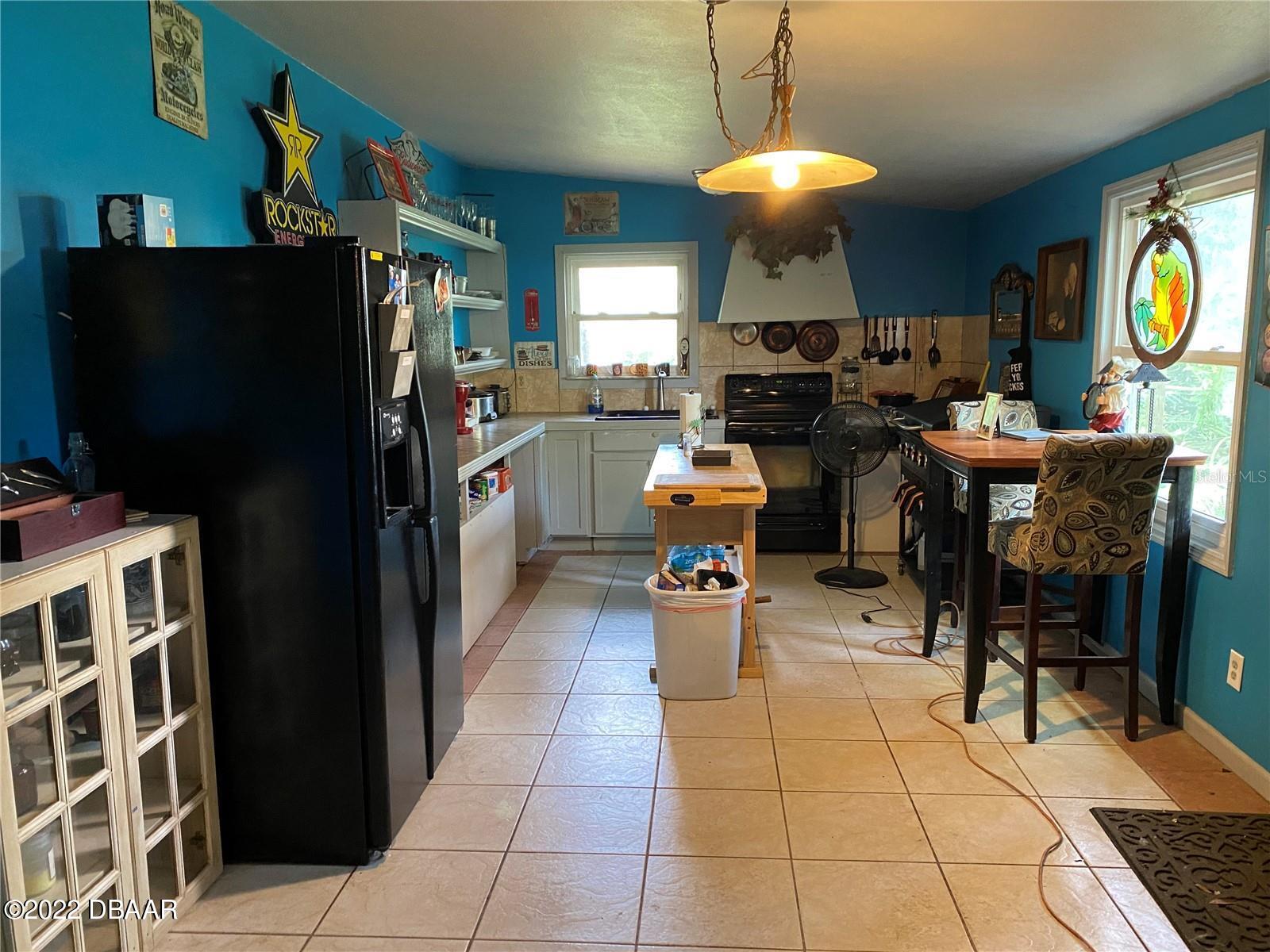 4580 Ave D St. Augustine, FL 32095 - Photo 6 of 10 a kitchen with stainless steel appliances granite countertop a dining table and chairs
