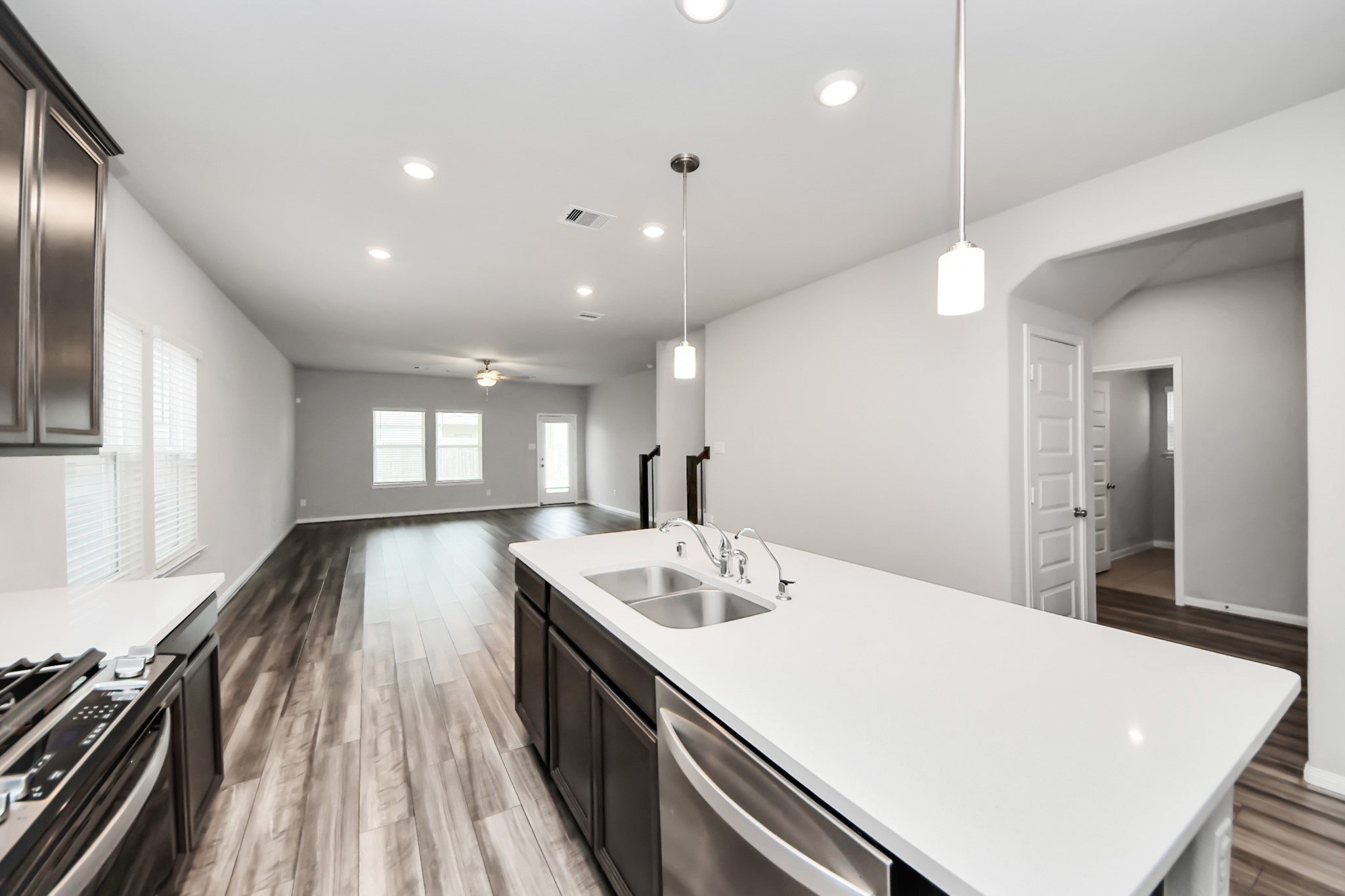 7206 Melrose Lane Rosharon, TX 77583 - Photo 11 of 44 a large white kitchen with a large island oven a sink dishwasher and refrigerator with wooden floor
