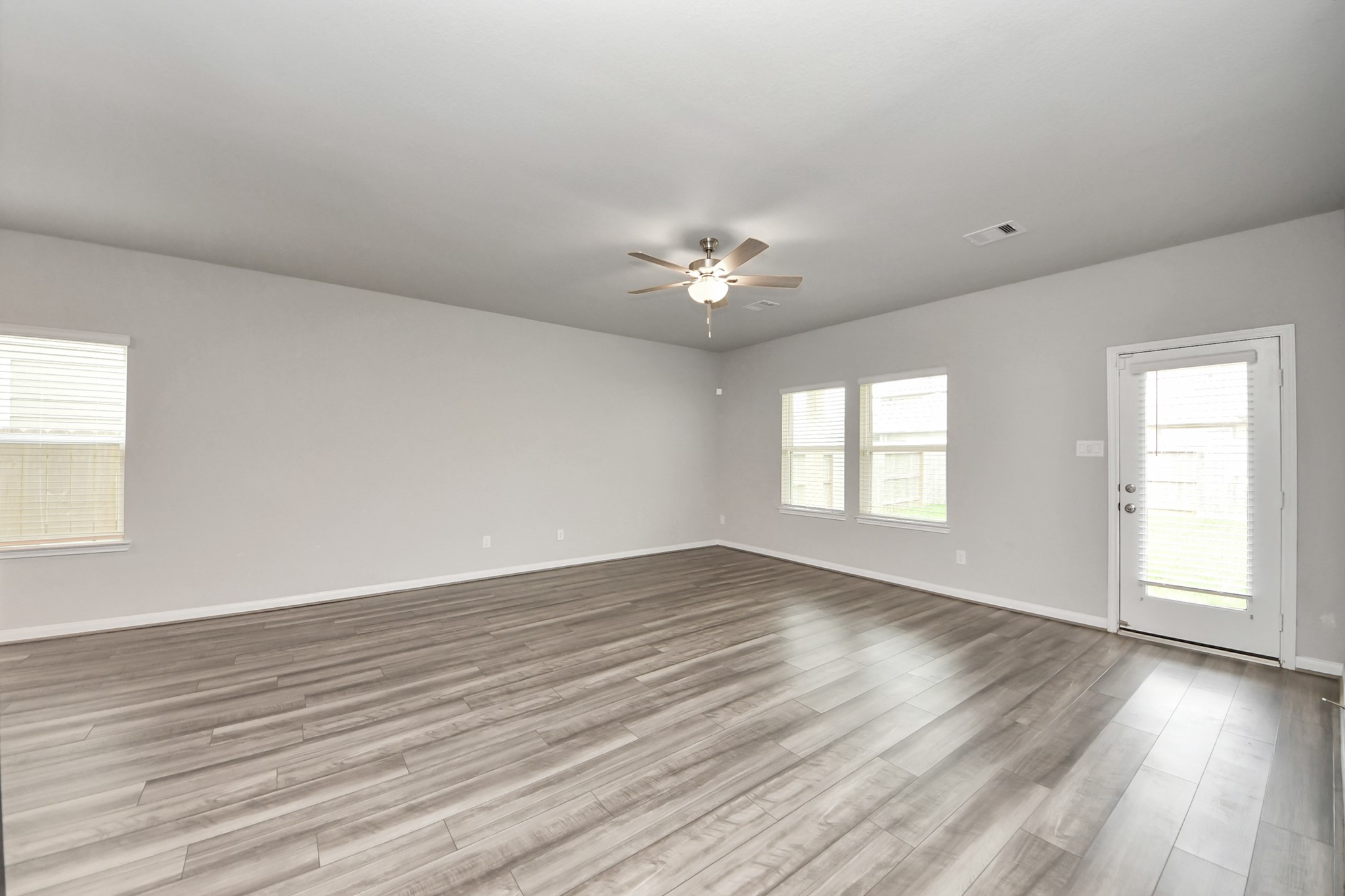 7206 Melrose Lane Rosharon, TX 77583 - Photo 20 of 44 an empty room with wooden floor and windows