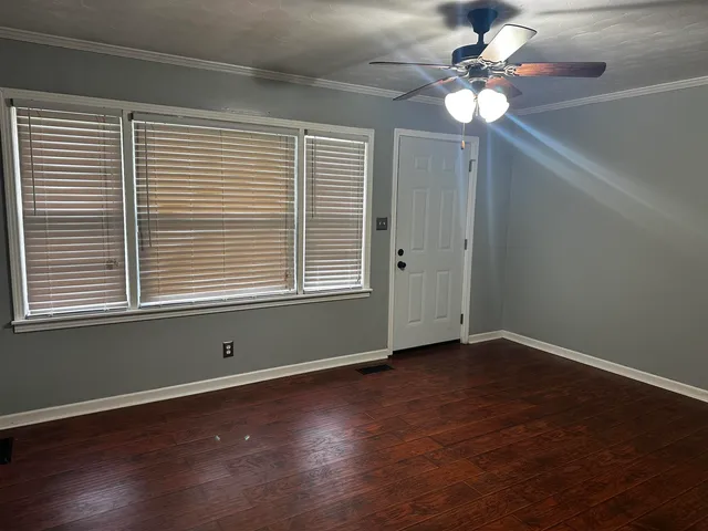 a kitchen with granite countertop wooden cabinets and a wooden floor