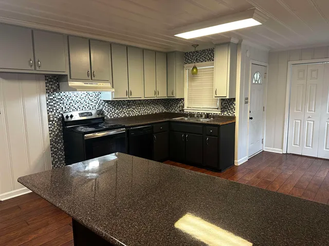 an empty room with wooden floor a exposed radiator and a window