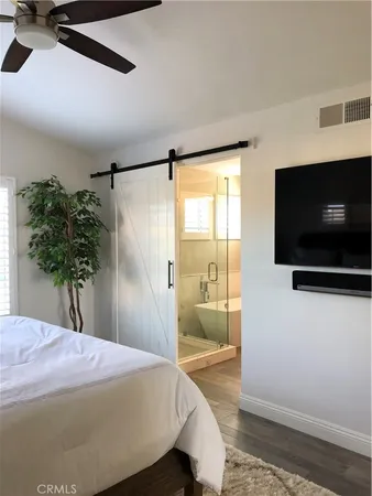 a bedroom with a bed and a flat screen tv