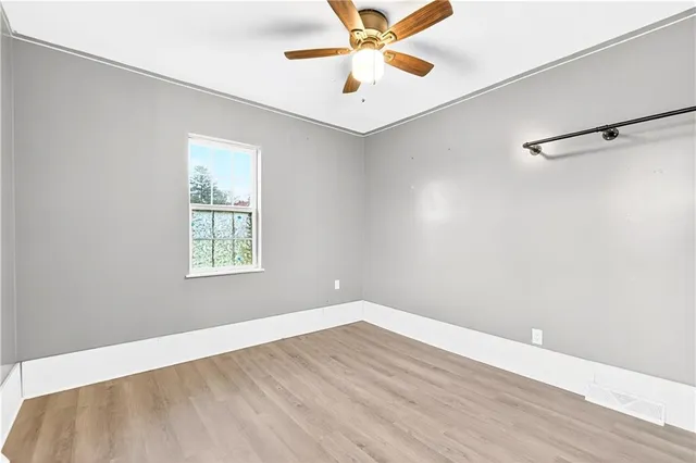 an empty room with a window and a ceiling fan