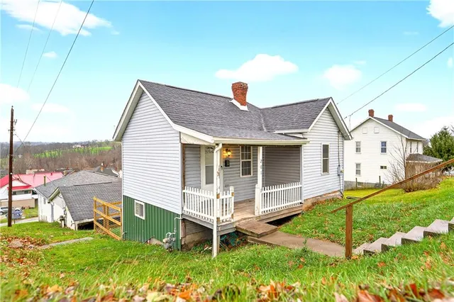a view of a house with a yard and sitting area