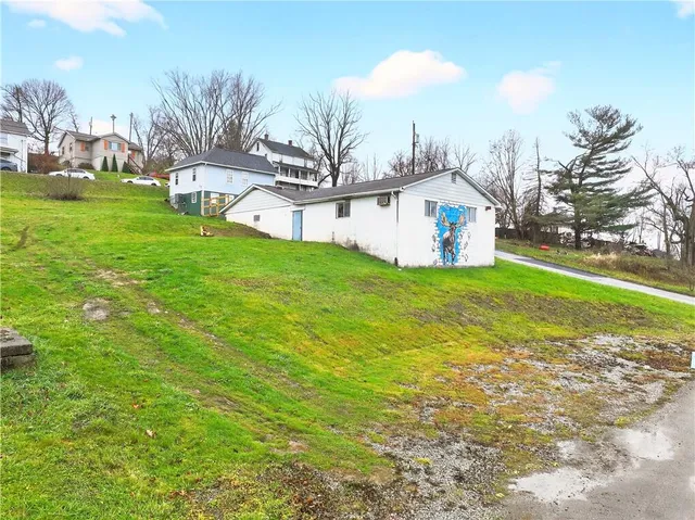 a view of a house with a yard and sitting area