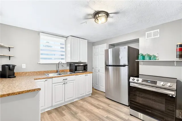 a kitchen with a sink appliances and cabinets