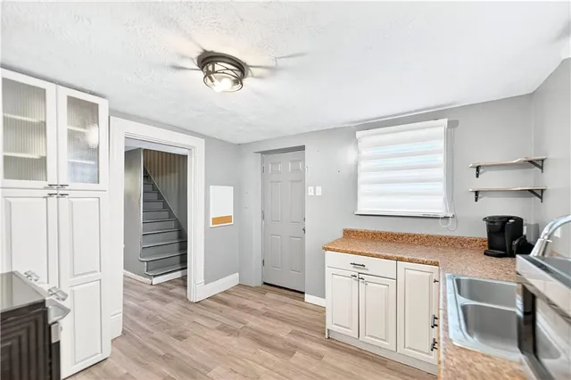 a kitchen with granite countertop a stove a sink and a refrigerator